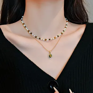 Dettaglio collana vintage placcata oro con perle occhio di tigre e ciondolo ovale