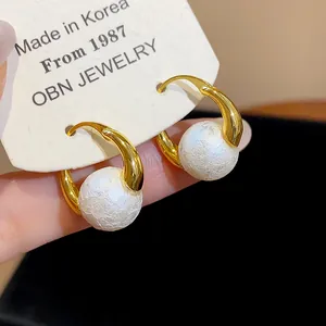 Detailed close-up of French vintage 18k gold plated hoop earrings with textured pearls