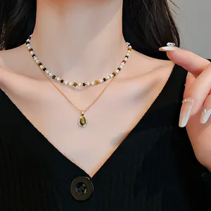 Primo piano di collana a doppio strato con ciondolo occhio di tigre e perline.