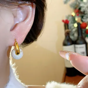 Close-up detail of a vintage 18k gold plated pearl hoop earring worn on a model's ear