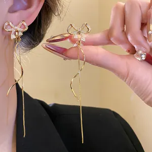 Detailansicht der eleganten Gold-Schleifen-Quasten-Ohrclips mit funkelnden Zirkonia