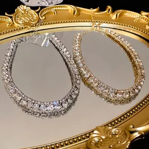 Elegant gold and silver rhinestone tennis necklaces displayed on a vintage mirror tray
