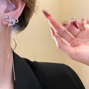 Detailansicht von 18 Karat vergoldeten Schleifenohrringen mit funkelnden Zirkon-Quasten