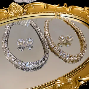 Detail view of elegant rhinestone necklace and square stud earring sets on a mirror