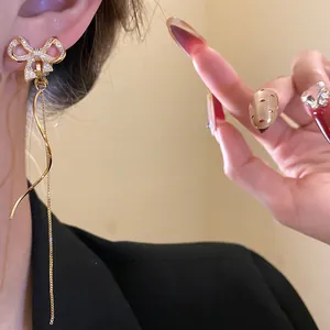 Detailansicht der 18k vergoldeten Zirkon-Schleifenohrclips mit Quasten am Modell.