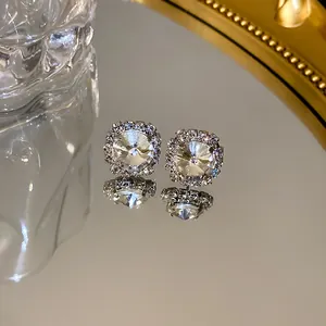 Detailed close-up of square halo rhinestone stud earrings reflecting on a luxury mirror