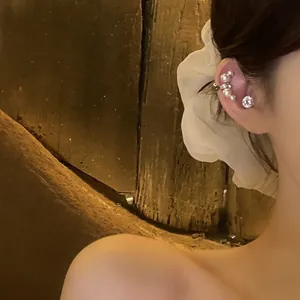 Close-up detail of an elegant French retro zircon and pearl ear cuff earring on model's ear