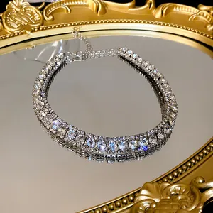 Close-up of a brilliant double-row rhinestone choker necklace on a gold mirror