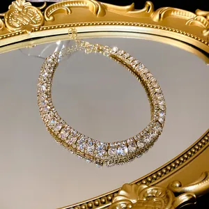 Close-up of luxury sparkling multi-row rhinestone choker necklace on a vintage gold mirror tray