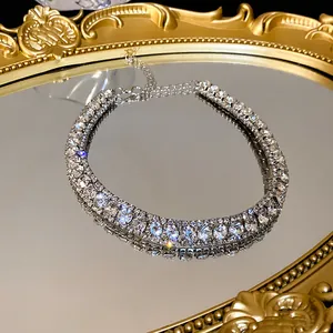 Close-up view of a luxury double-row rhinestone choker necklace placed on a golden mirror tray