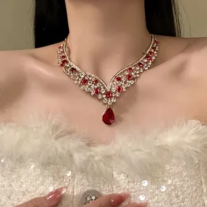 Close-up of a vintage luxury necklace with red zircon waterdrop pendant and rhinestones.