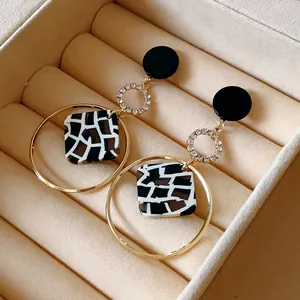 Detalle de pendientes cuadrados retro de leopardo en marco geométrico