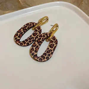 Primer plano detallado de pendientes vintage de leopardo con eslabón de cadena dorada