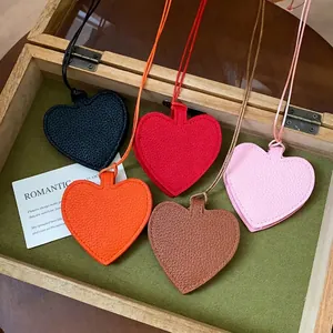 Colorful heart-shaped leather pendants in a wooden gift box display