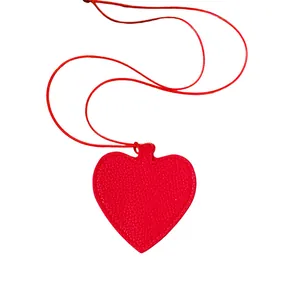 Red leather heart-shaped pendant necklace and sunglasses storage accessory on white background.