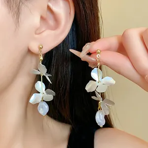 Close-up detail of elegant French-style floral petal earrings with white baroque pearls