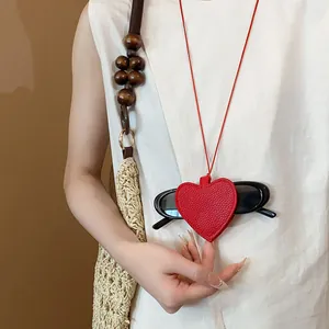 Red leather heart pendant necklace used as a stylish sunglasses storage holder case.