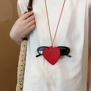 Close-up detail of a red leather heart-shaped sunglasses holder necklace for women