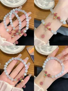 Detailed views of grey cat's eye stone bracelet with strawberry charms