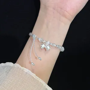 Detailed view of handmade cat eye stone bracelet with silver lily of the valley charms