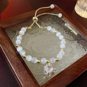 Elegantes handgemachtes Katzenaugen-Perlenarmband in Weiß mit Goldakzenten und Zirkonia-Anhänger.