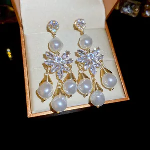 Dettaglio di orecchini di lusso con cristalli scintillanti e perle bianche eleganti