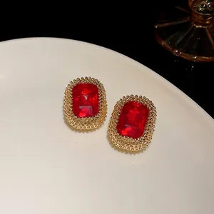 Dettaglio degli orecchini vintage in cristallo rosso rettangolare con i bordi dorati