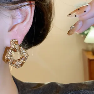 Detailaufnahme von vergoldeten Zirkonia-Ohrringen im Vintage-Stil am Ohr