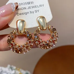 Nahaufnahme von vergoldeten Ohrringen mit champagnerfarbenem Zirkonia im Vintage-Hofstil