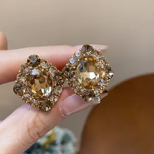Nahaufnahme von vergoldeten Ohrringen im Vintage-Hofstil mit elegantem champagnerfarbenem Zirkon