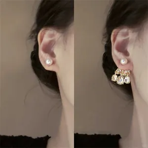 Detalle de pendientes de perlas y chaquetas de pendientes de cristal en oreja.