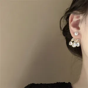 Detalle de primer plano de elegantes pendientes de perlas y cristales de gota en la oreja