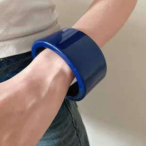 Primo piano dettagliato della trama liscia di un grosso braccialetto in resina blu scuro