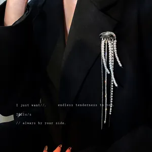 Elegant jellyfish brooch with long pearl and rhinestone tassels on a black blazer.
