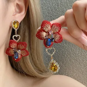 Orecchini asimmetrici a fiori con ricamo rosso e strass gialli a goccia d'acqua.