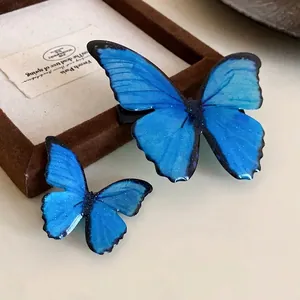 Set of two vibrant blue butterfly hair clips with glossy finish for forest style
