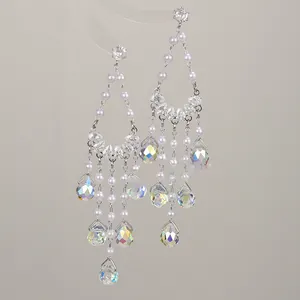 Detailed macro view of bohemian tassel earrings featuring white pearls and iridescent crystals.