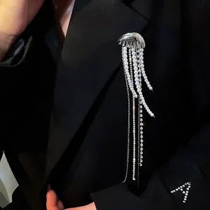 Macro detail of a jellyfish brooch with pearl tassels on a black blazer.
