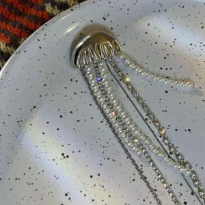 Close-up of elegant jellyfish brooch featuring long pearl and rhinestone tassels