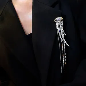 Close-up of an elegant silver jellyfish brooch with long pearl and rhinestone tassels