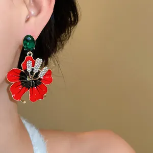 Primo piano di un elegante orecchino a fiore rosso retrò francese con strass scintillanti