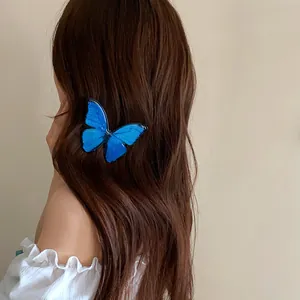 Close-up of a vibrant blue butterfly hair clip worn on long brown hair