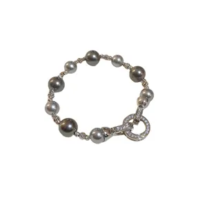 Elegante bracciale con perle e zirconi con chiusura circolare in cristallo brillante.