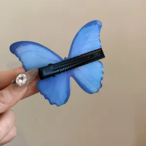 Back view detail of blue butterfly hair clip showing sturdy black alligator clip