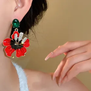 Eleganti orecchini vintage francesi a fiore in smalto rosso con dettagli in cristalli brillanti.