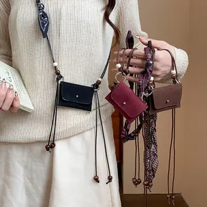 Dettaglio della catena da vita in tessuto stile etnico con mini borsa e legna