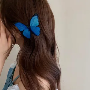 Detailed view of a vibrant blue butterfly hair clip styled on wavy brown long hair