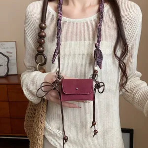 Dettaglio di pochette etnica in tessuto con perle in legno per la vita