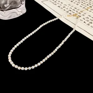 Detailed view of white square beads and gold spacers on a minimalist choker necklace