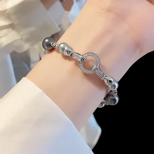 Primo piano di un elegante bracciale di perle in stile francese con anelli di zirconi.